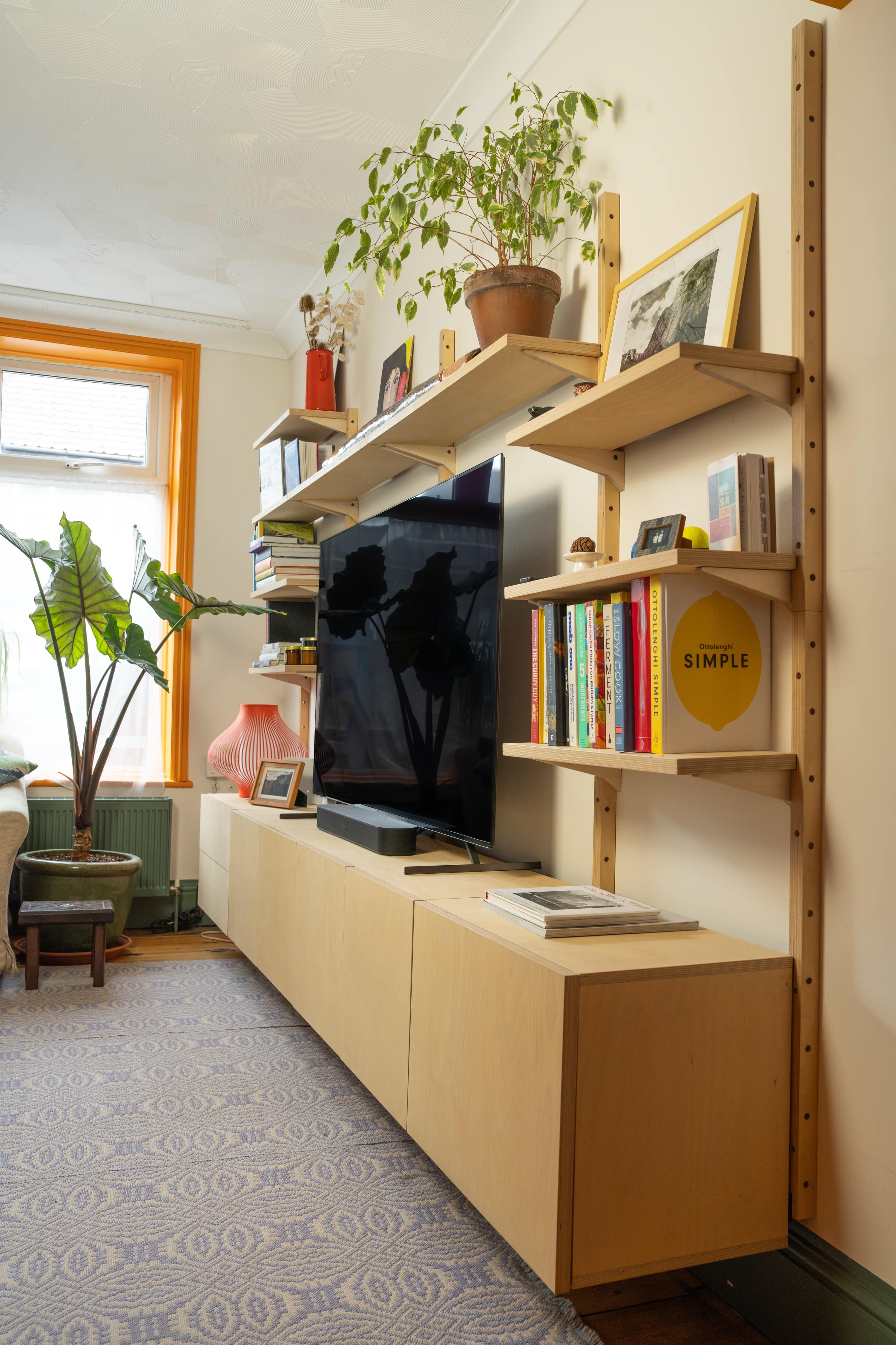 Wall-mounted wooden modular shelving units and cabinet in a living room